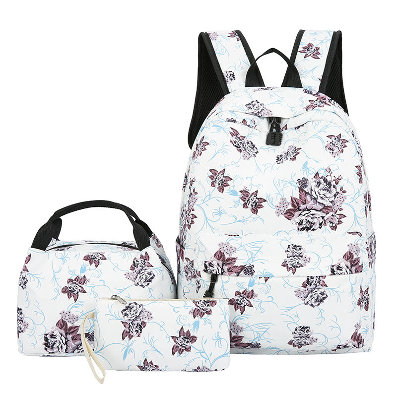Floral-patterned backpack, lunch bag, and pouch on a white background