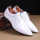 White dress shoes with black soles on a brown surface