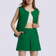 Woman wearing a green vest and shorts set on a light purple background