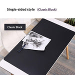 Black desk mat on a white desk with a plant and stationery items, labeled 'Single-sided style Classic Black'.