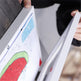 Person holding a book with a watermelon illustration on a blurred background
