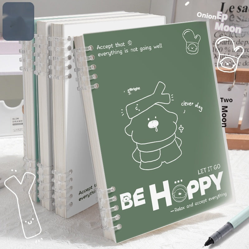 Notebook with a green cover featuring a bear illustration and text, placed on a surface.