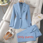Light blue suit with pants, shoes, and handbag on a gray sofa.