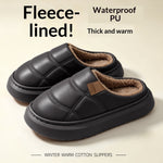 A pair of black fleece-lined slip-on slippers with quilted panels and a soft brown interior, shown on a light beige background with promotional text reading 'Fleece-lined!', 'Waterproof PU Thick and warm', and 'Winter Warm Cotton Slippers'.