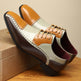 Pair of brown and beige leather shoes on a wooden surface with a beige background