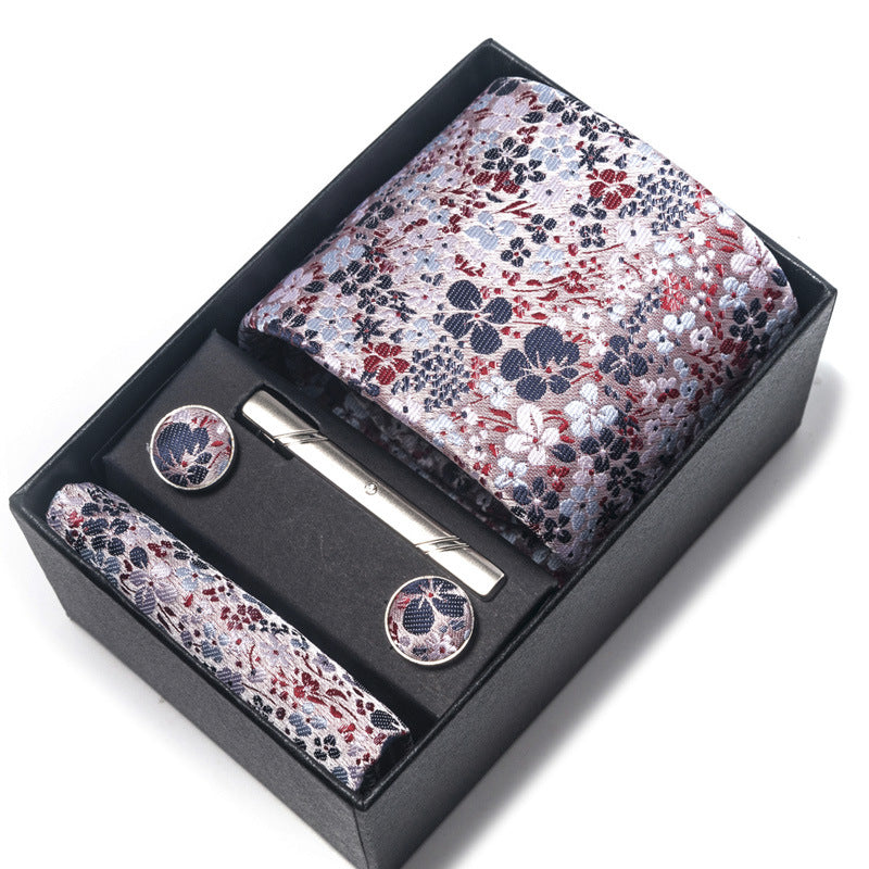 Floral patterned tie set with tie clip and pocket square in a black box on a white background