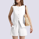 Woman wearing a white sleeveless top and shorts with a gold handbag on a light gray background