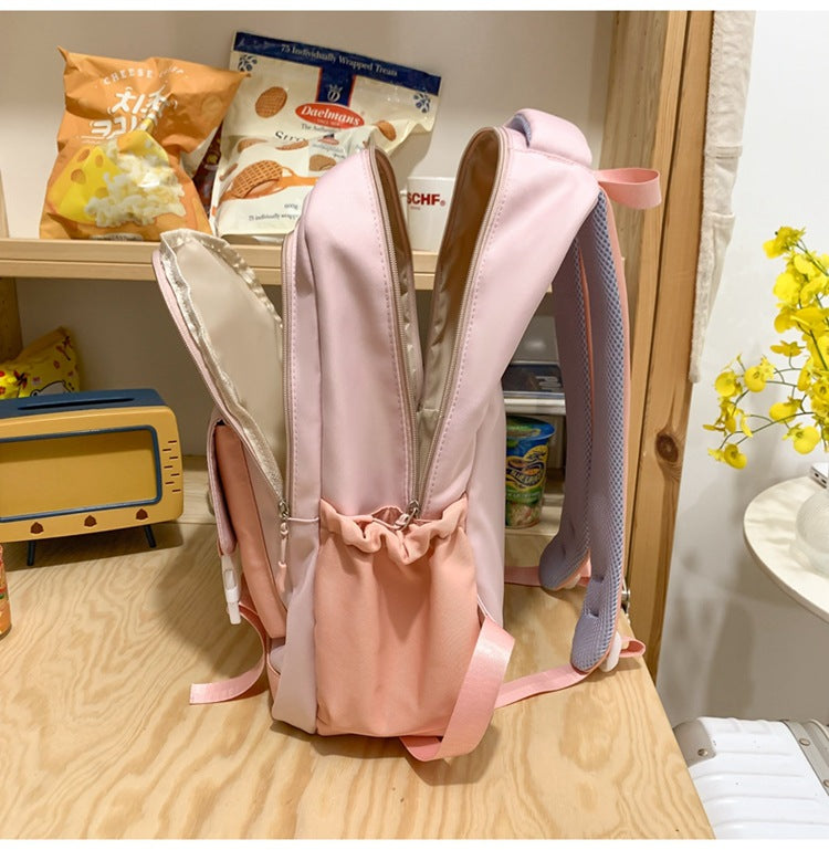 Pink backpack with bunny ears on a wooden surface