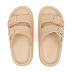 Pair of beige sandals with buckle straps on a white background