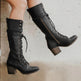 Black lace-up boots on a neutral background