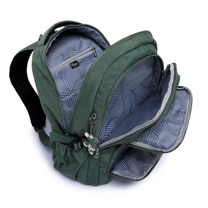 Green backpack with open compartments on a white background