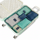 A mint green suitcase opened to show packing cubes and travel organization bags inside. The set includes gray, teal, and navy fabric packing cubes with navy labels reading 'SECRET POUCH' and 'SECRET BAG'.