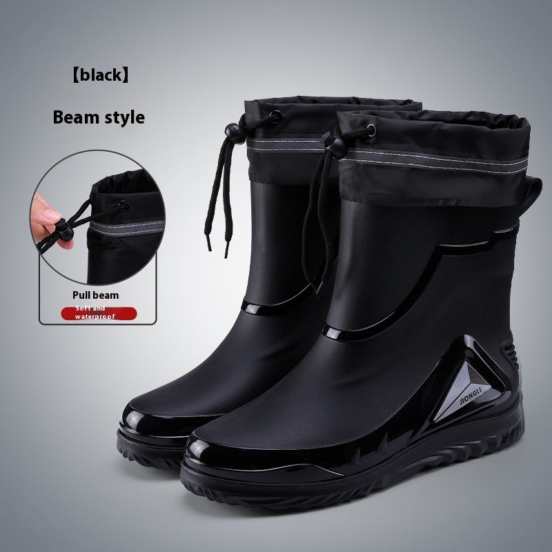 Black rain boots with pull beam feature on a gray background