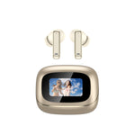 A pair of wireless earbuds above their matching charging case on a plain white background. The earbuds and case have a warm champagne-gold metallic finish, while the screen on the case displays a colorful photo of two women outdoors.
