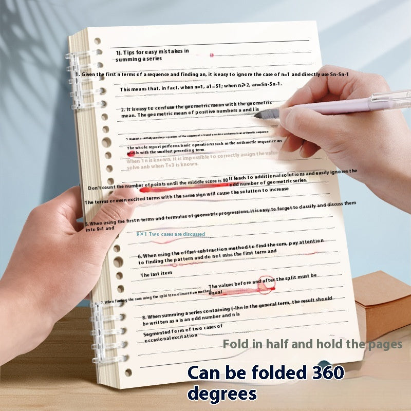 A spiral-bound notebook shown being held open by two hands, with a pen writing on a page. The pages are folded in half to demonstrate a 360-degree fold, with text at the bottom reading 'Fold in half and hold the pages' and 'Can be folded 360 degrees.