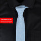 Light blue tie on a black shirt with a red item number label.