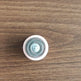 Round white object with blue pattern on a wooden surface