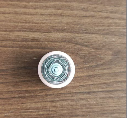 Round white object with blue pattern on a wooden surface