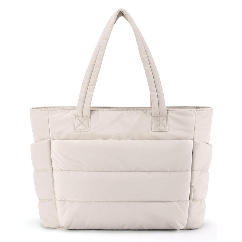 Beige tote bag with multiple pockets on a white background
