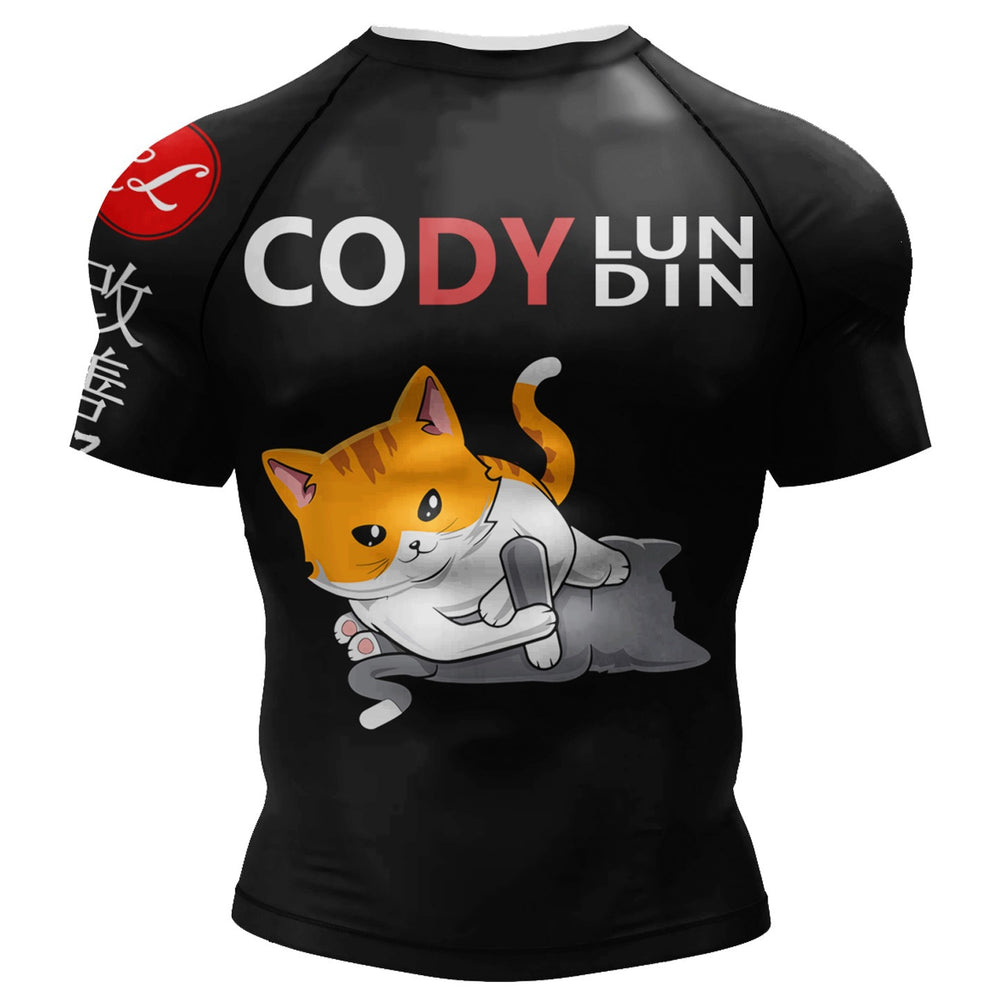 Black short-sleeve athletic rash guard with a cartoon orange-and-white cat graphic on the back, large 'CODY LUNDIN' text across the upper back, and a red circular logo on the sleeve, shown on a white background.