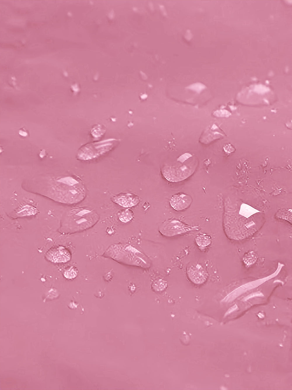 A close-up of a pink textured surface covered with clear water droplets.