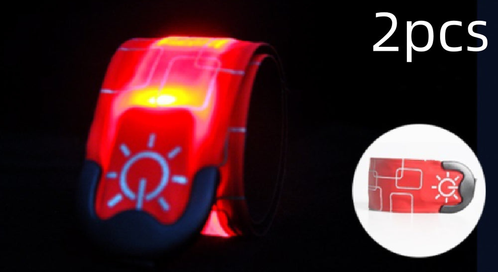 Two red reflective wristbands with a sun symbol on a black background