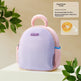 Purple pet carrier with pink handle on a beige background