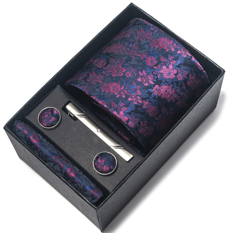 Floral tie set with tie, tie clip, and cufflinks in a black box on a white background