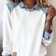 White sweatshirt with denim collar and cuffs worn by a person.