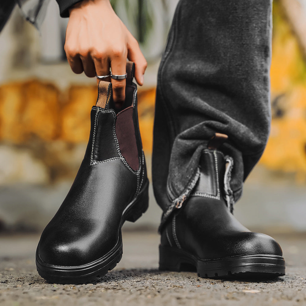 Person wearing black leather boots with a blurred outdoor background