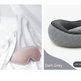 A split-panel product image showing a dark grey travel neck pillow on the right and a matching sleep mask on the left, styled on white fabric with a small pinecone prop. Text on the panel reads 'Dark Grey' and notes a waterproof storage bag.