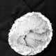 Close-up of a black garment with a large circular opening showing fluffy white faux-fur lining.