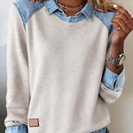 Light-colored sweatshirt with denim collar and cuffs worn by a person.