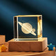 Crystal block with 3D Saturn engraving on a wooden base against a dark blue background