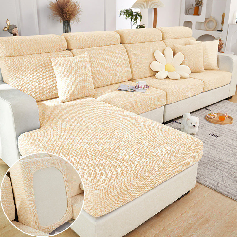 Beige sectional sofa with floral pillow in a living room setting