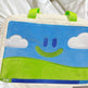 Children's pillow with smiley face design on a white blanket