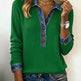 Green sweater with denim collar and cuffs worn by a person on a plain background