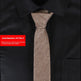 Brown tie on a black shirt with a red item number label.