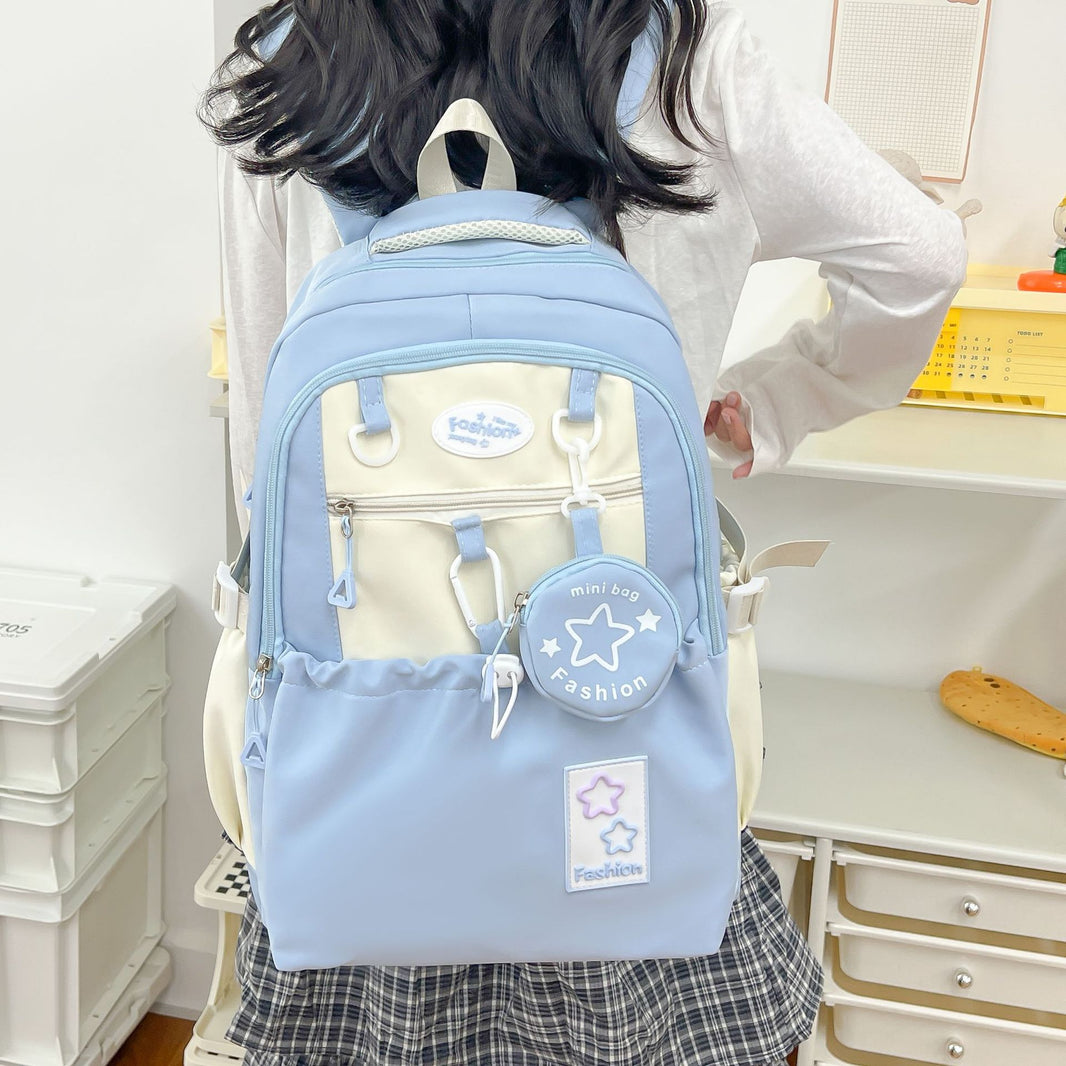 Person wearing a light blue backpack with star designs in a room.