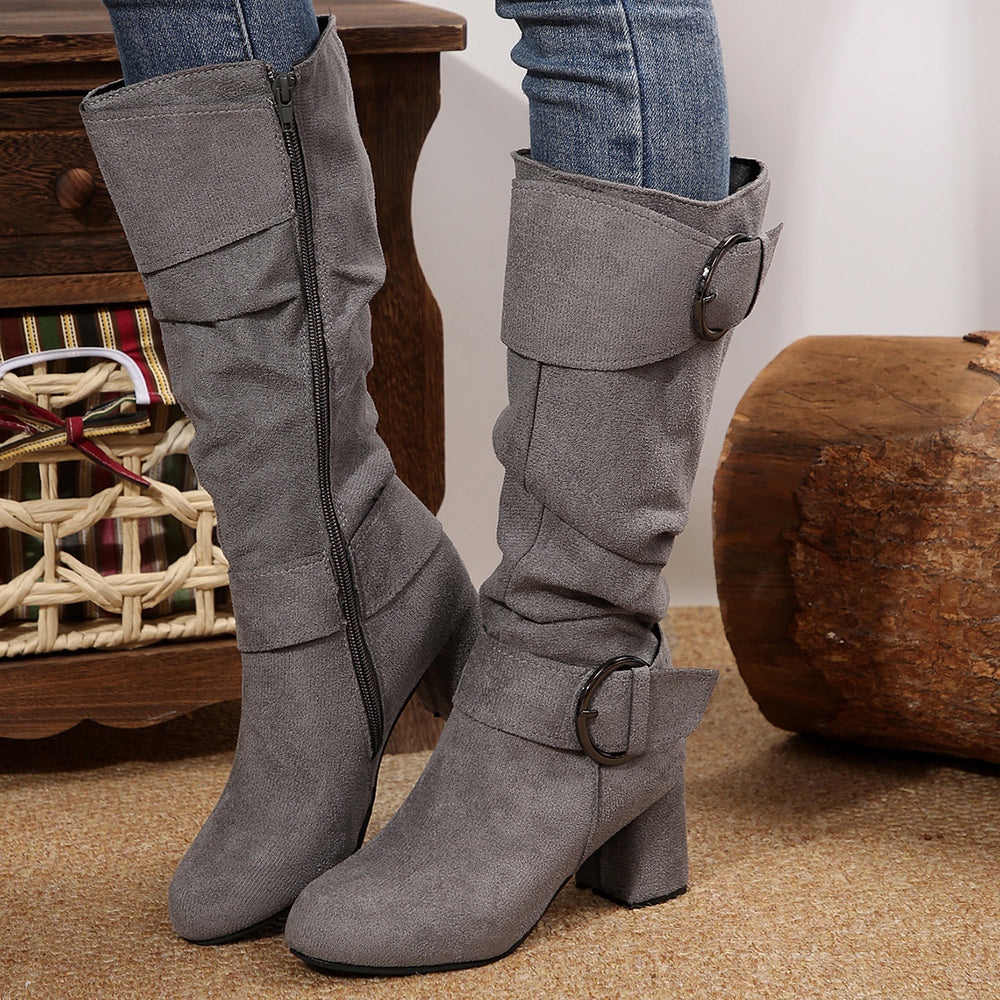 Gray knee-high boots with buckles worn by a person, standing on a carpeted floor.