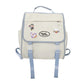 Beige backpack with cartoon character stickers on a white background