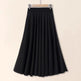 Black skirt on a hanger against a beige background