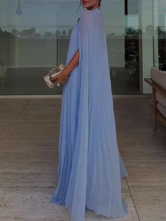 Woman in a light blue dress holding a clutch in an indoor setting.