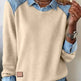 Beige sweater with denim collar and cuffs worn by a person.