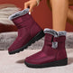 Maroon winter boots with gray fur trim worn by a person on a neutral background