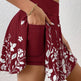 Maroon skirt with white floral pattern worn by a person against a white background