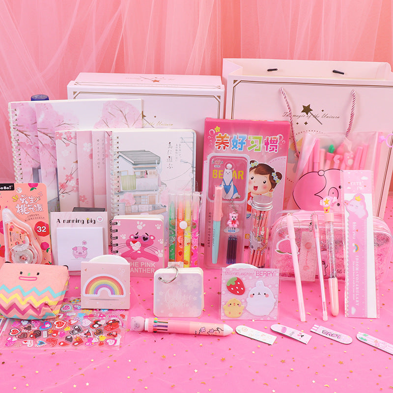 Collection of pink stationery items on a pink background
