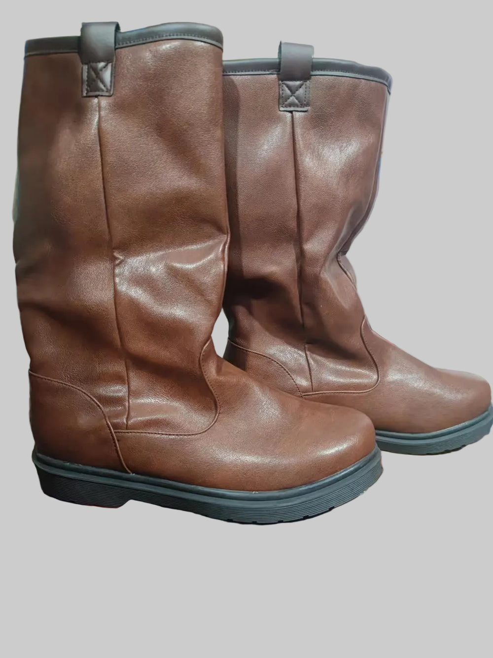 Pair of brown leather boots on a colorful surface with a blurred background