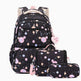 A matching backpack and school accessory set on a white background. The set includes a black backpack with a pastel cosmic print, a small shoulder bag, a pencil case, and a heart-shaped tag that reads 'Bustle Girl'.