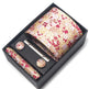 Floral tie set with tie, tie clip, and cufflinks in a black box on a white background